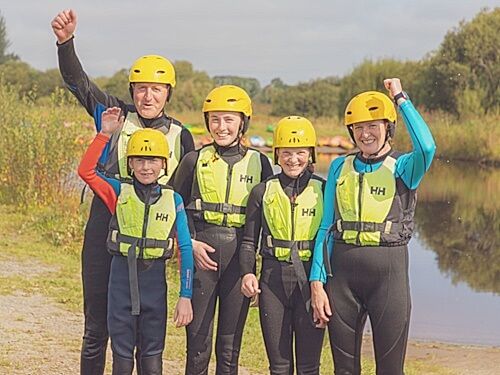 Family of four looking happy before going kayaking
